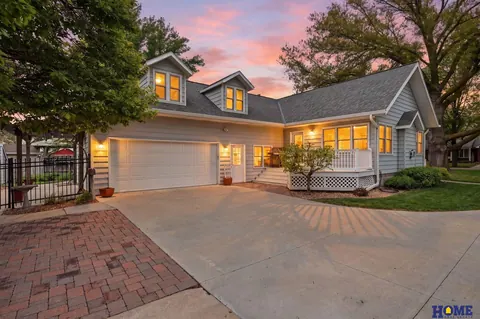 207 W 4th Street: 207 W 4th Street at dusk, gray siding and lit dormers above the attached garage