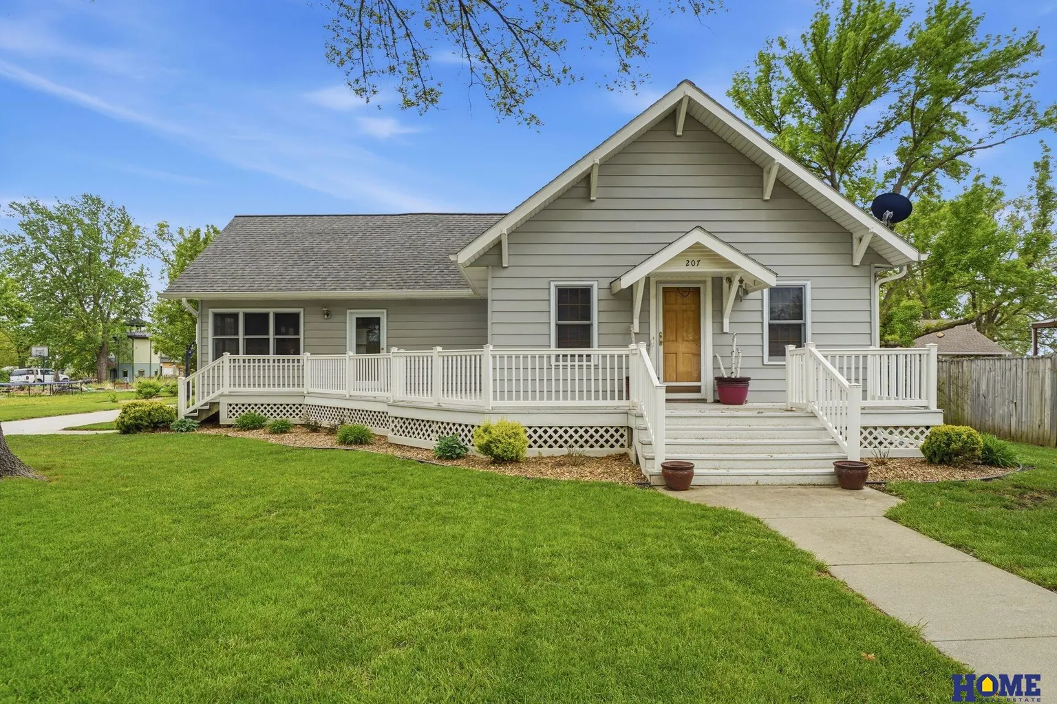 207 W 4th Street: front of the home: covered porch with white railings and a gabled entry