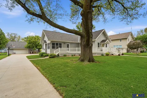 207 W 4th Street: front of the home from the sidewalk, with a mature tree in the yard