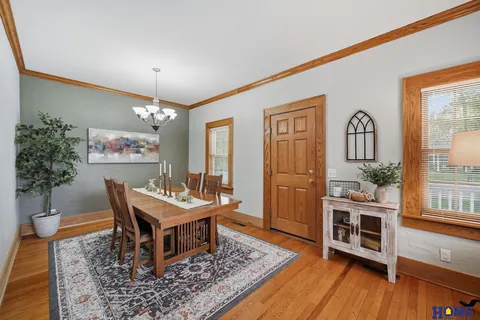 207 W 4th Street: formal dining room with a chandelier and arched-top wood doors