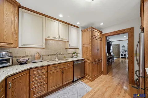 207 W 4th Street: kitchen: white upper cabinets, oak lowers and a tile backsplash