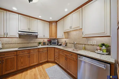 207 W 4th Street: kitchen with a stainless dishwasher and oak cabinets
