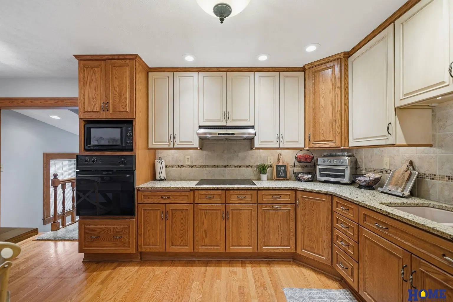 207 W 4th Street: kitchen with a stacked wall oven and microwave in oak cabinetry