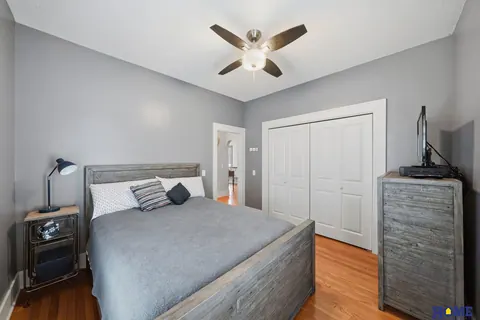 207 W 4th Street: main-floor bedroom with wood floors and a ceiling fan