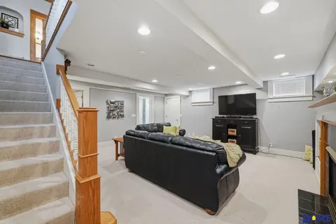 207 W 4th Street: basement family room with recessed lights and the stair