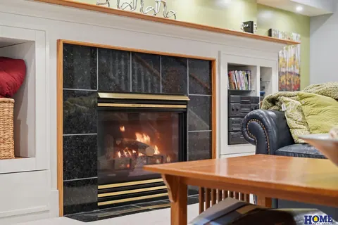 207 W 4th Street: basement fireplace framed in black tile with white built-ins